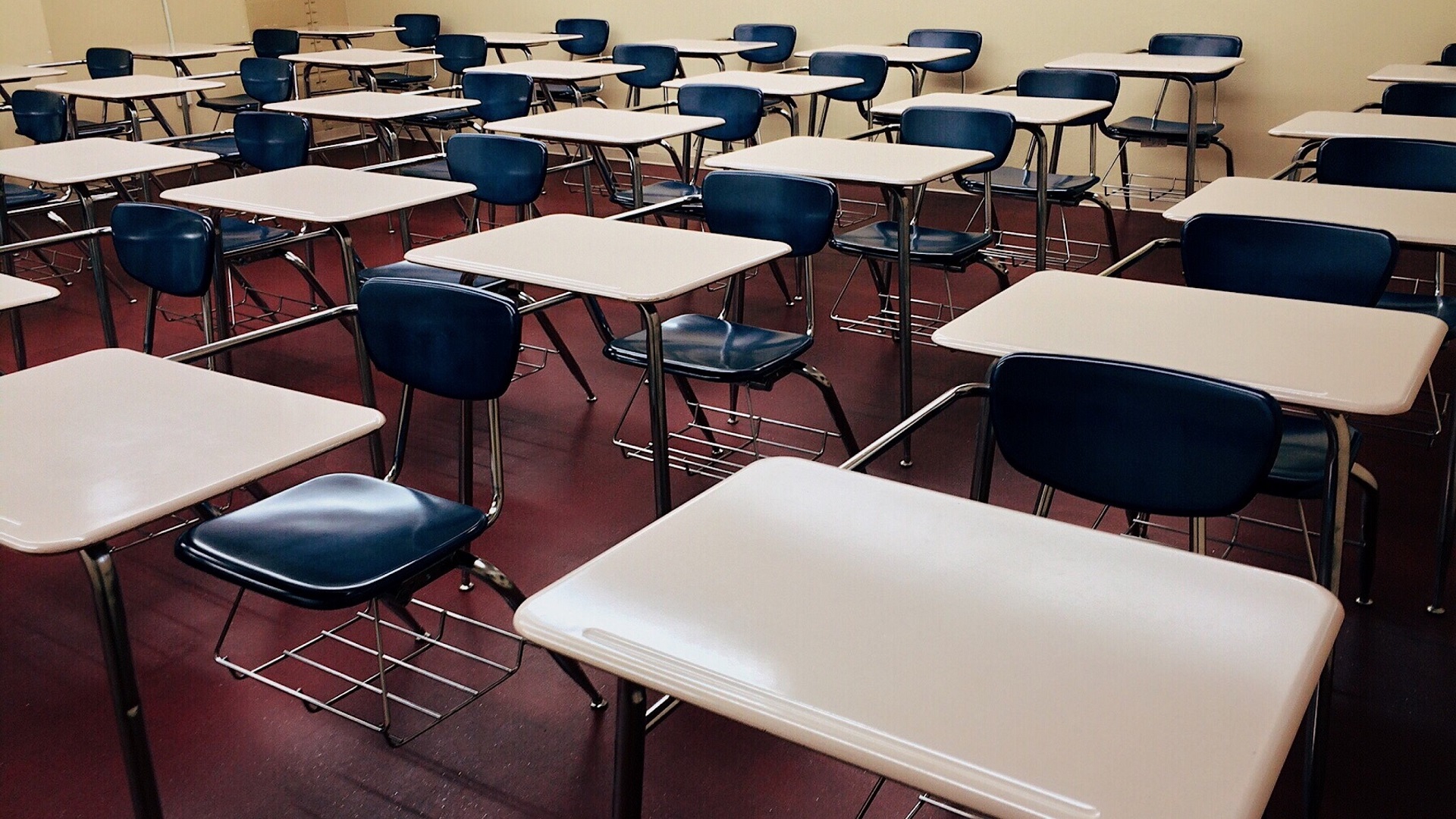 A classroom full of empty desks and chairs.
