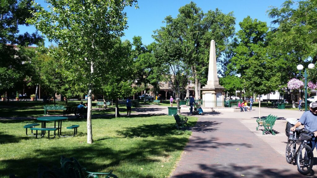 Santa Fe Plaza, with a focus on a white obelisk at the center.