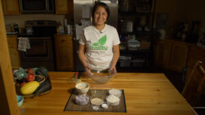 A person stands in front of prepared ingredients in a kitchen.
