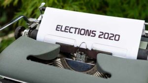 A typewriter in a grassy area, with paper reading "ELECTIONS 2020".