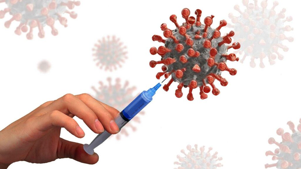 Illustration of a hand injecting a giant coronavirus with a syringe.