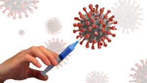Illustration of a hand injecting a giant coronavirus with a syringe.