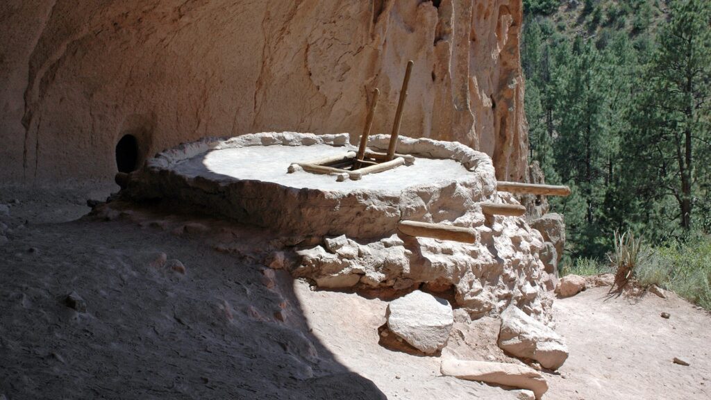 A platform sits in a shady area of a rocky structure.