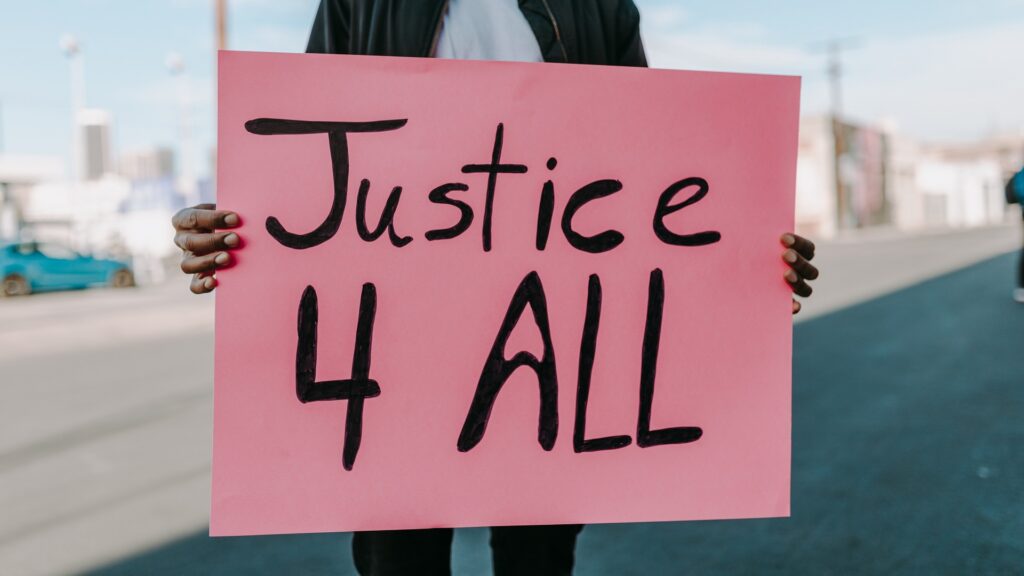 Someone holding a pink sign reading "Justice 4 ALL".