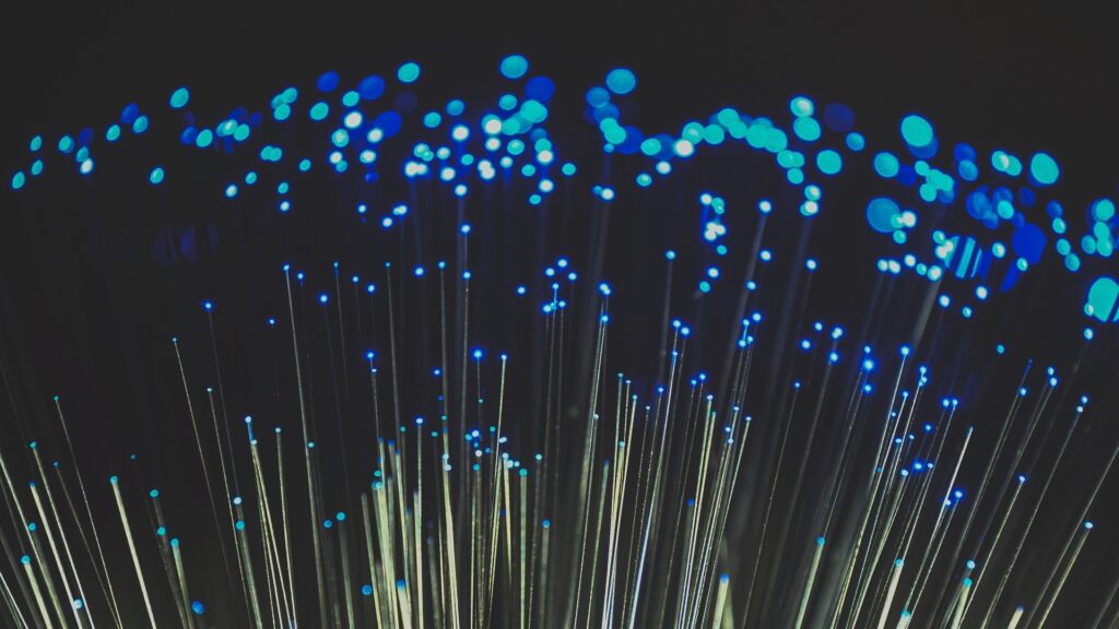 Close-up of cluster of fiber optic cables, illuminated at one end.