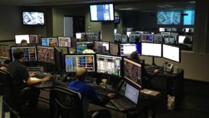 Control room for spaceflight, with several people sitting in front of busy computer monitors.