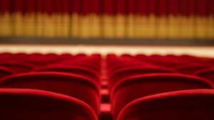 Close-up, blurry shot of empty theatre chairs.