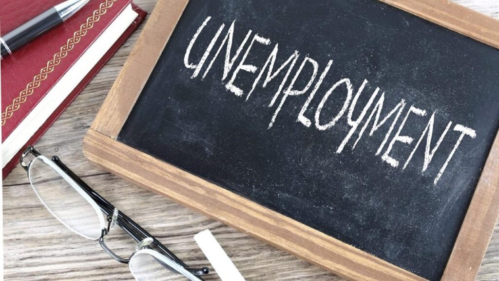 A small chalkboard with "UNEMPLOYMENT" written on it.