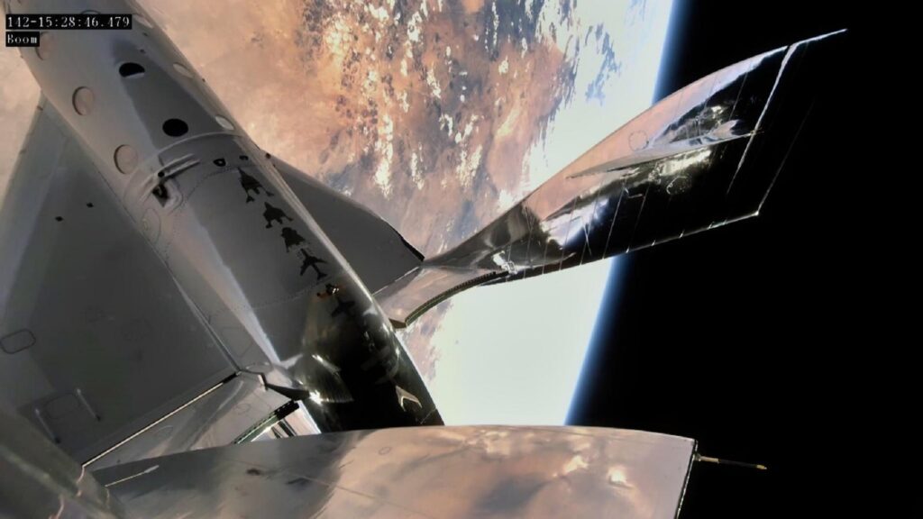 Exterior view of a Virgin Galactic spaceship orbiting Earth.