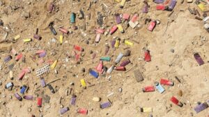 Shell casings scattered on sandy ground.