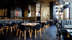 A rustic restaurant floor filled with empty tables and chairs.