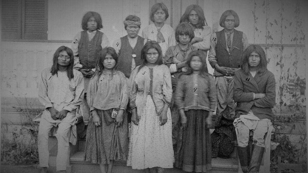 Portrait of a group of young Apache people as they attend a boarding school.