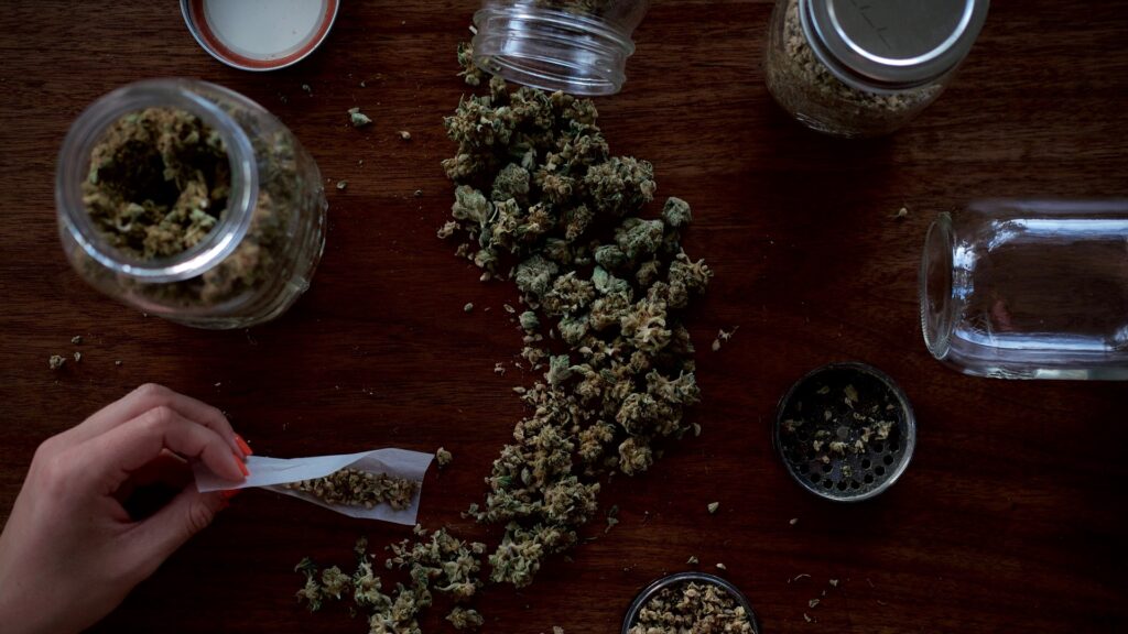 A mason jar of cannabis spilled on a table.
