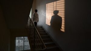 A child standing in a dark stairway.