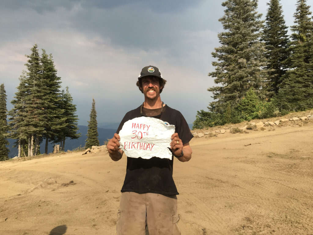 A man holding a "Happy Birthday" sign