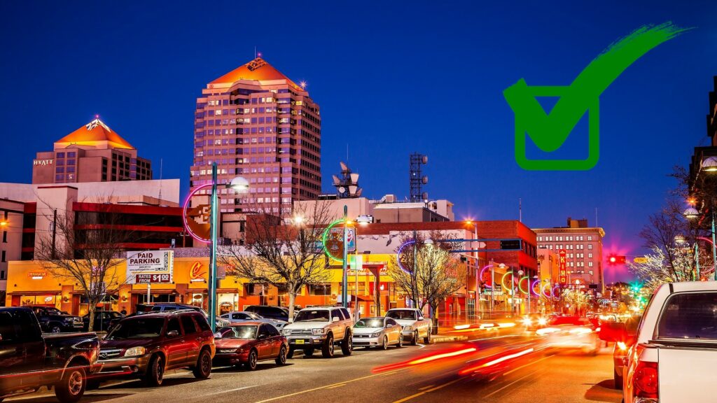 Downtown Albuquerque at Night with a green square and check mark graphic