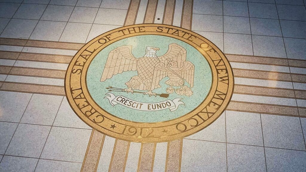 Seal of The State of New Mexico printed on a tile floor.