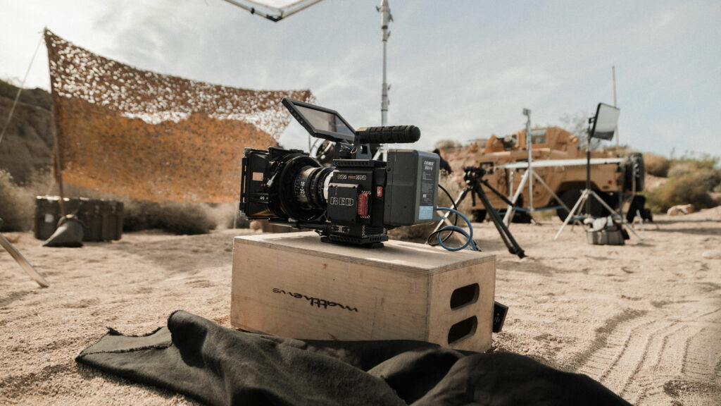 A camera sitting on a box in the middle of an outdoors film set.