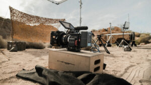 A camera sitting on a box in the middle of an outdoors film set.