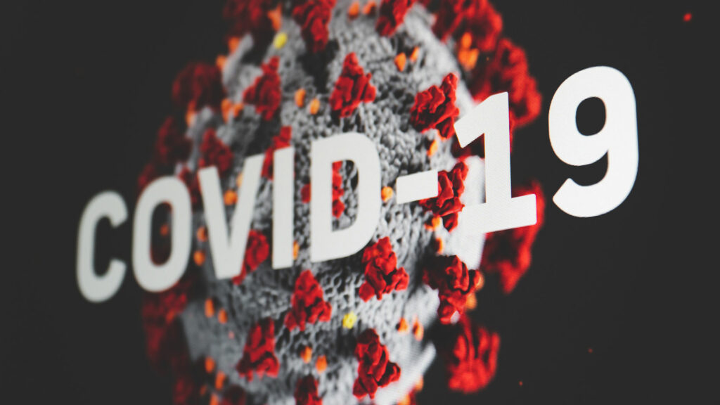 A graphic of a close up molecule of Covid-19 with "Covid-19" superimposed.