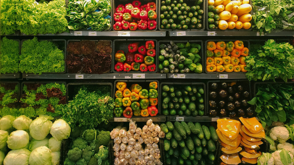 The produce section of a grocery store with rows of vegetables.