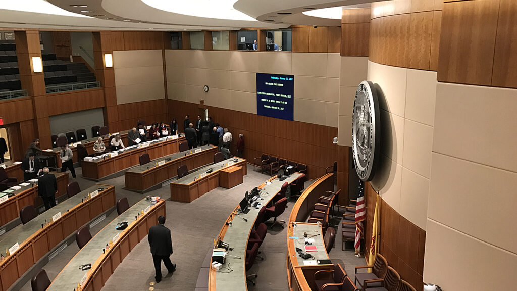 A group of people standing in a courtroom.