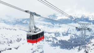 A cable-car traveling over a snow covered landscape.