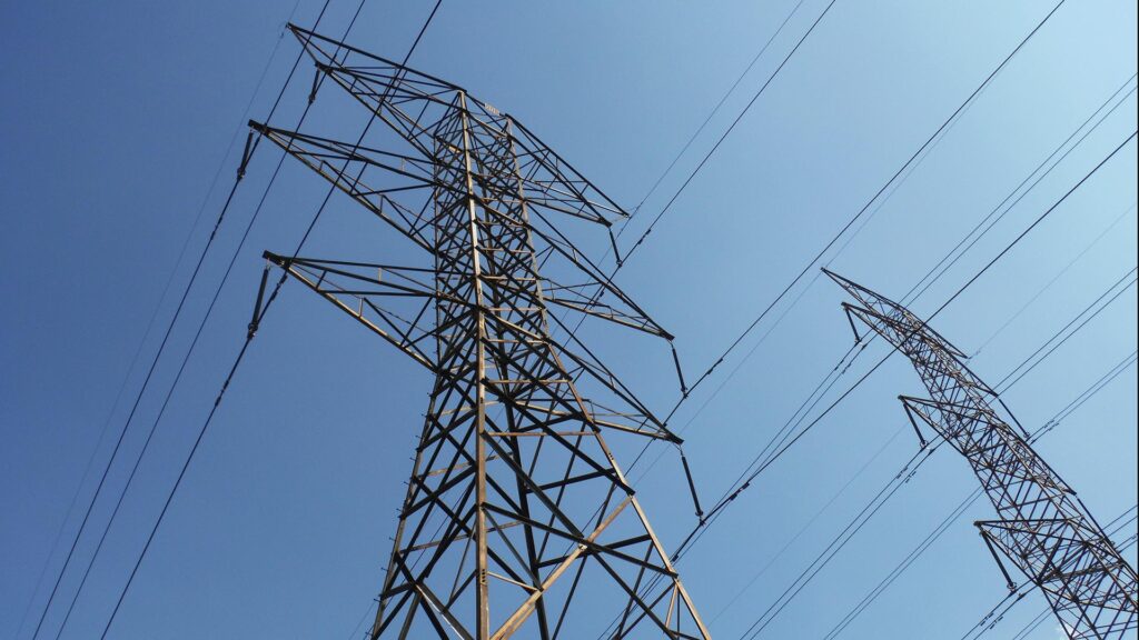 High voltage power lines against a blue sky.
