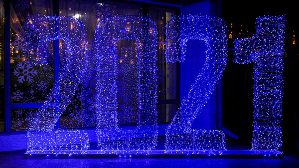 A wire sculpture that spells out "2021" covered in lights.