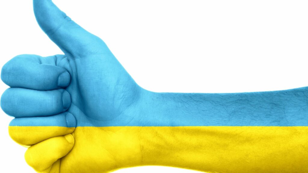 A persons hand giving a "thumbs-up" with the Ukraine Flag's coloring.