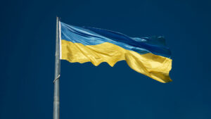 The flag of Ukraine on a pole with the wind running through it.
