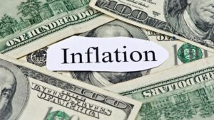 A pile of money with a piece of paper in the middle that says "Inflation."