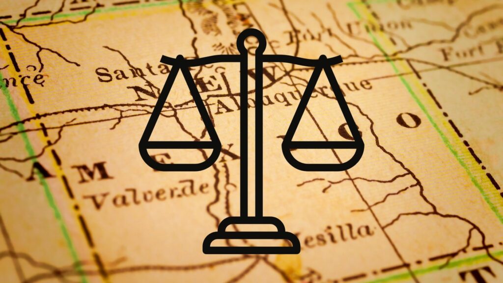 A cartoon drawing of the scales of justice over a map background.
