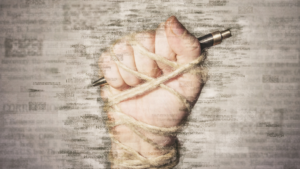 A blurry hand with a pen in their fist.