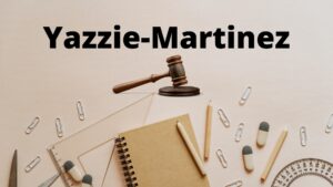 A table of office supplies and a gavel with the words "Yazzie-Martinez" on top.
