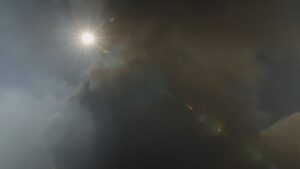 The sky obscured by a cloud of wildfire smoke with a lens flare from the sun.