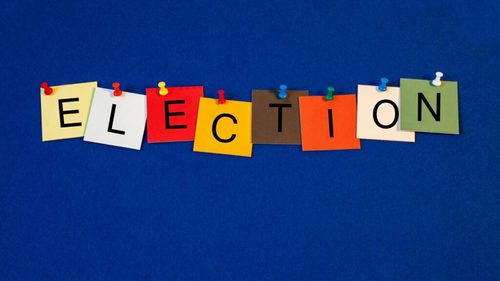 The word "election" written out on colorful cards and pinned to the wall.