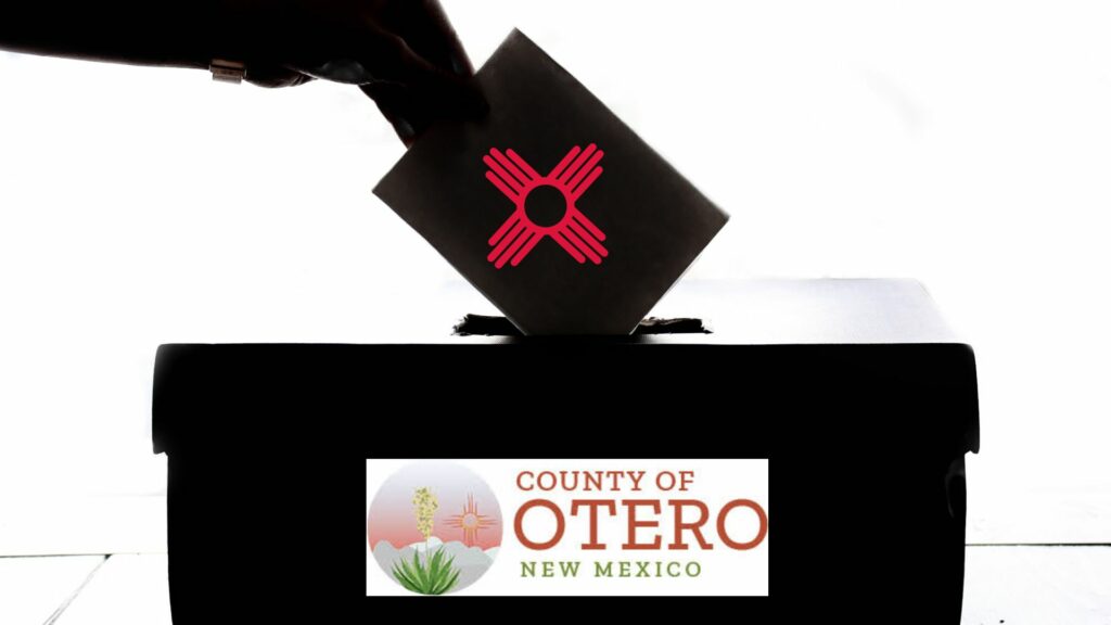 Someone putting a ballot into a box that says "County of Otero."