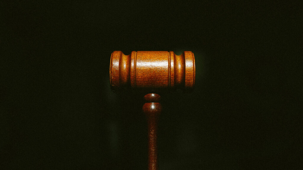 A wooden gavel on a dark background.
