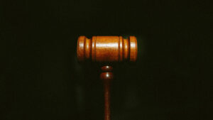 A wooden gavel on a dark background.