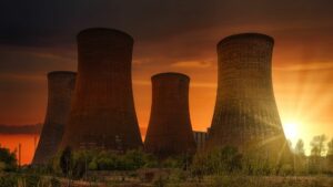 nuclear smoke stacks silhouetted by a sunset.