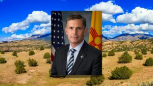 A portrait of Senator Martin Heinrich on top of a New Mexico landscape.