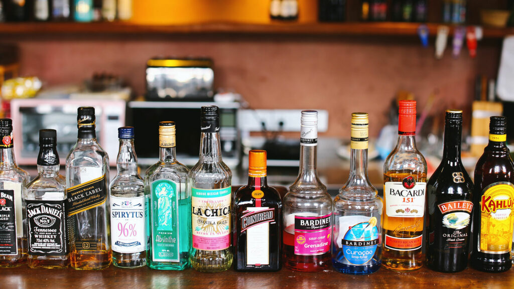 A row of liquor bottles lined up on a table.