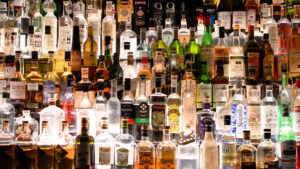 A wall of bottles of alcohol at a bar.