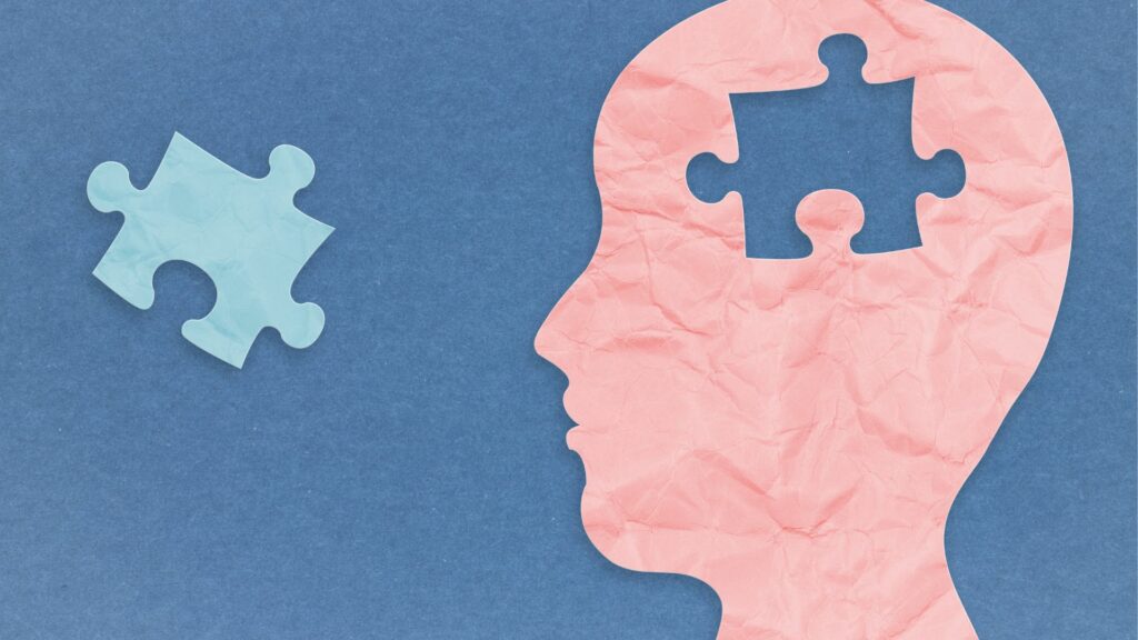 A graphic of a head with a missing puzzle piece in the brain region with a matching piece floating away from the head.