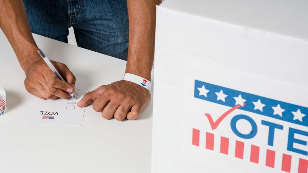 A person casting a vote on a fake ballot.