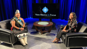 Two women sitting in chairs on a television set.