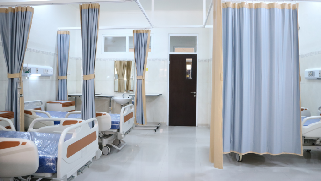 A hospital with beds and curtains.