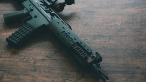 A green ak-47 rifle on a wooden table.