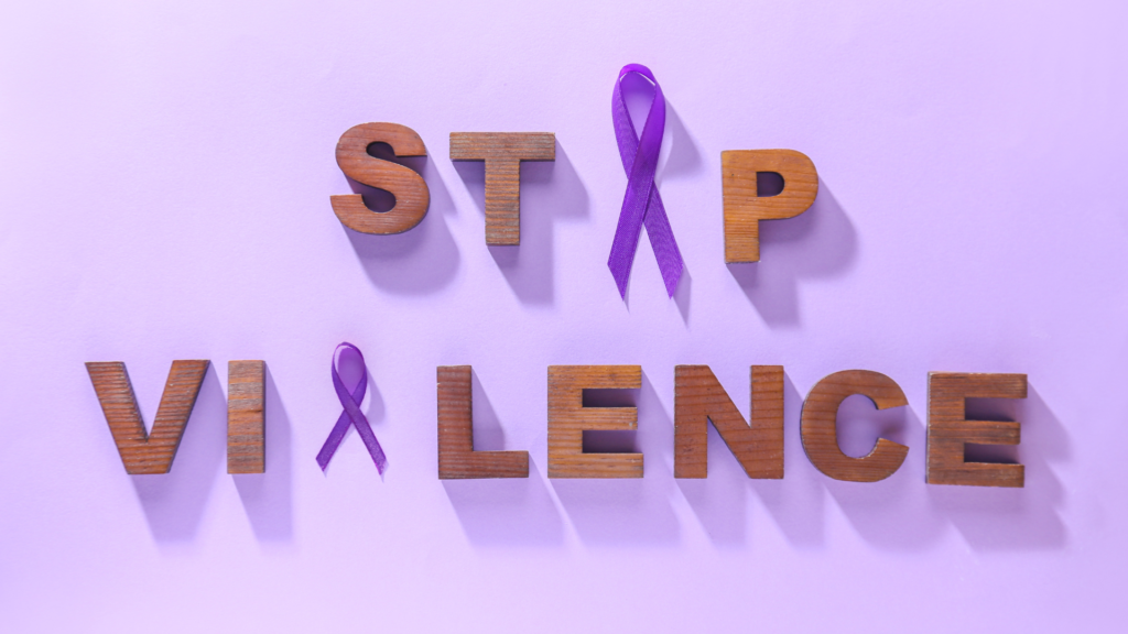 A graphic that says "stop violence" made out of wooden letters and purple ribbons for Domestic Violence awareness.
